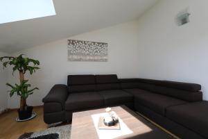 a living room with a black couch and a table at Luxury Villa Nada with Pool in Petrcane