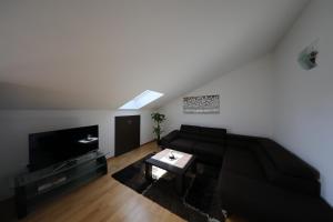 a living room with a black couch and a tv at Luxury Villa Nada with Pool in Petrcane