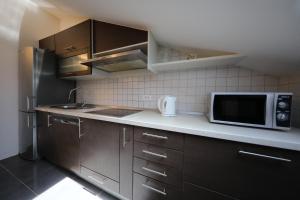 a kitchen with brown cabinets and a microwave at Luxury Villa Nada with Pool in Petrcane