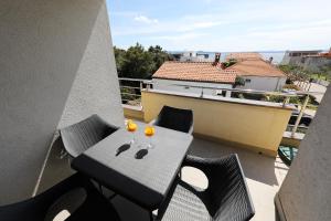 a table and chairs on a balcony with wine glasses at Luxury Villa Nada with Pool in Petrcane