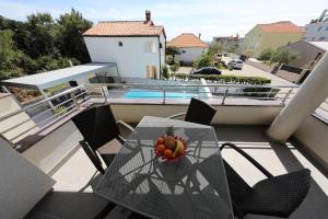 a bowl of fruit on a glass table on a balcony at Luxury Villa Nada with Pool in Petrcane