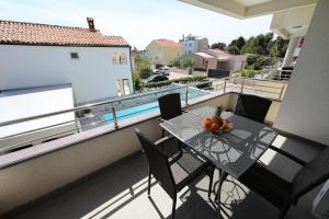 a table on a balcony with a bowl of fruit on it at Luxury Villa Nada with Pool in Petrcane