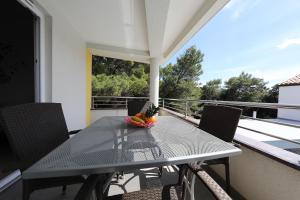 a table with a bowl of fruit on a balcony at Luxury Villa Nada with Pool in Petrcane