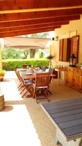 un patio con mesa y sillas bajo una sombrilla en Finca Miralles, en Búger