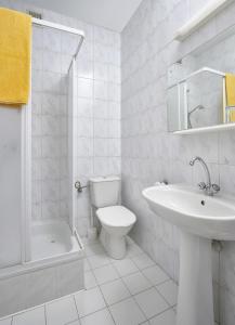 a white bathroom with a sink and a toilet at Vistula Hotel in Świecie