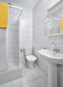 biała łazienka z umywalką i toaletą w obiekcie Vistula Hotel w mieście Świecie