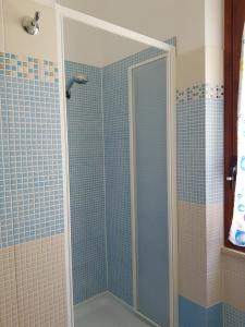 a shower with a glass door in a bathroom at Appartamento tra mare e montagna in Baunei