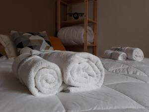 uma pilha de toalhas sentadas em cima de uma cama em CASAMILA em Gorizia