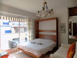 sypialnia z łóżkiem i dużym oknem w obiekcie Le Meyerbeer Promenade w Nicei