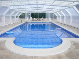 an indoor swimming pool with a white ceiling at Alojamento Local Céu-Azul in Porto de Mós