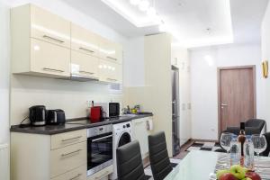 una cocina con armarios blancos y una mesa con sillas. en 3 En Suit bedroom flat in the main centre for 6ppl, 3BDR,3BTHR,AC, en Budapest