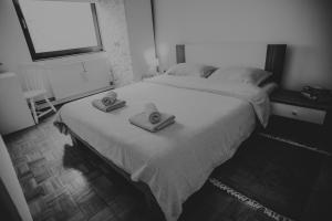 a black and white photo of a bed with towels on it at Petros apartmani in Vukovar