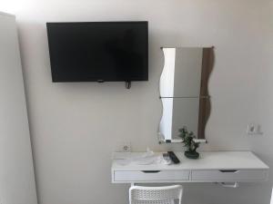 TV de pantalla plana colgada en una pared blanca en ATICI HOTEL en Antalya