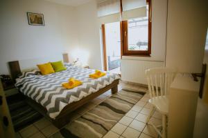 a bedroom with a bed with yellow shoes on it at Petros apartmani in Vukovar