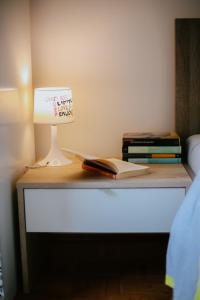 a table with a lamp and books on it at Petros apartmani in Vukovar