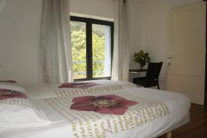 two beds in a room with a window at DOMAINE DU MURIER in Die