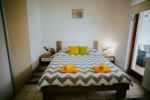 a bedroom with a bed with yellow shoes on it at Petros apartmani in Vukovar