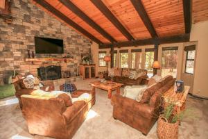 a living room with leather furniture and a stone fireplace at The Lodge at Snow Summit Home in Big Bear Lake