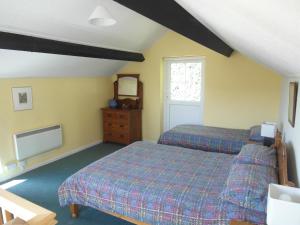 a bedroom with two beds and a tv in it at Woodcliffe Holiday Apartments in Ventnor