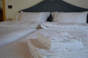 a bed with white towels on top of it at B&B Arlanch 8 in Vallarsa