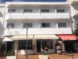 a white building with a store in front of it at Hostal de la Caravel-la in Cala d´Or
