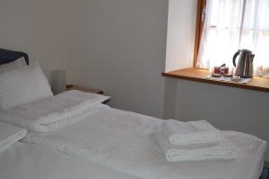 een wit bed met handdoeken in een kamer bij B&B Arlanch 8 in Vallarsa