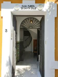 una entrada a una casa con un arco y escaleras en Casa Puerta de Santa Cruz, en Sevilla