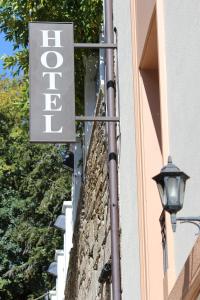 a sign on the side of a building with a street light at Hotel Herradura in Santiago de Compostela