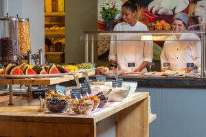 a buffet line with fruits and vegetables on display at St Svithun Hotel in Stavanger