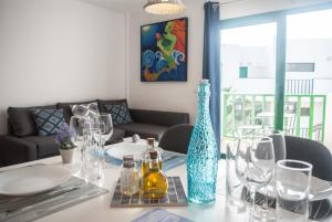 a table with glasses and a blue vase on it at Fuerteventura Park 4 in Costa de Antigua