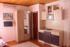 a small kitchen with a sink and a door at Apartmani Pavičić-Ivelja in Stari Grad