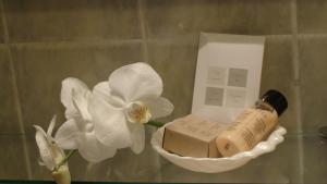 a bottle of soap and a white flower in a bathroom at Hotel Cascade Superior in Düsseldorf +104 photos
