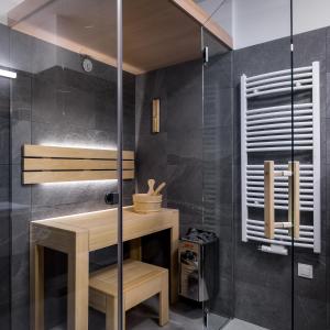 a bathroom with a wooden table and a shower stall at Green Apartments in Karpacz