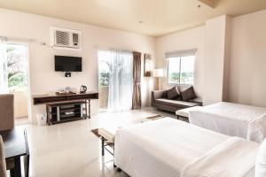 een woonkamer met een bed en een bank bij Sierra Hotel in Dumaguete