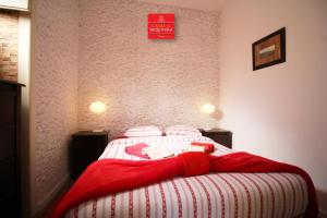 a bedroom with a bed with a red blanket on it at Casas da Biquinha in Sintra