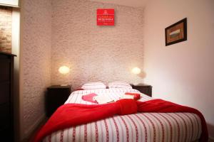 a bedroom with a bed with a red blanket on it at Casas da Biquinha in Sintra