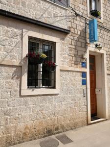 una ventana con macetas al lado de un edificio en Guest House Klaudija, en Trogir