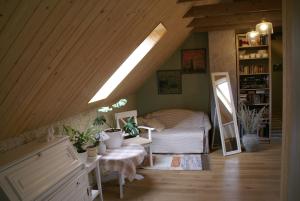 a attic room with a bed and a mirror at Dzērves in Araiši