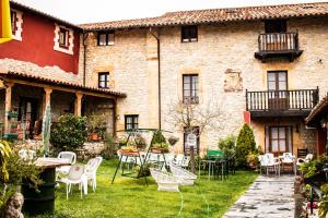 a courtyard of an old building with chairs and tables at Posada de Bielva in Bielva