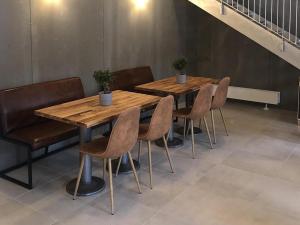 two wooden tables and chairs in a room at B & B Gødstrup - cafe og restaurant Den Gamle Stald in Herning