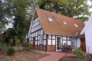 a white and black house with a table and chairs at Ferienwohnung Wildrose in Badbergen
