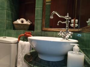 a bathroom with a sink and a toilet and a mirror at La Cabana´l Cachican in Cangas del Narcea +81 photos