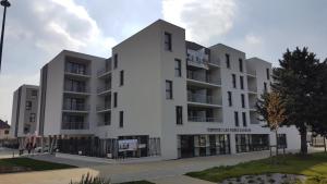 un edificio de apartamentos con fachada blanca en Domitys - Les Robes d'Airain, en Caen