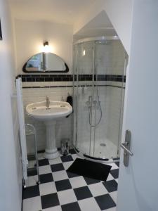 ein Bad mit einem Waschbecken und einer Dusche in der Unterkunft Atelier aux Dimes in Le Manoir