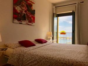 Un dormitorio con una cama y una ventana con vistas. en BellaVista Apartments, en Taormina