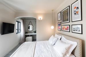 a hotel room with a white bed and white walls at Oniro City in Athens