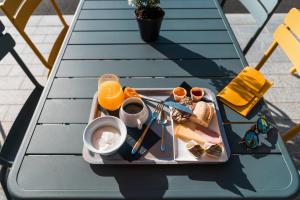 - un plateau de nourriture sur une table avec du jus d'orange dans l'établissement ibis Styles Nancy Sud, à Houdemont
