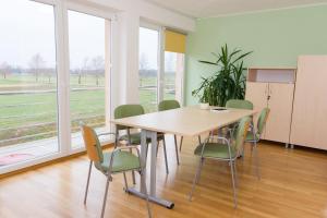 una sala de conferencias con mesa, sillas y ventanas en Apartma Murania, en Lendava