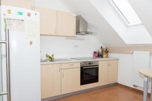 a kitchen with white cabinets and a skylight at Apartma Murania in Lendava