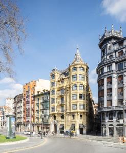 a large building in the middle of a street at Hotel Tayko Bilbao in Bilbao